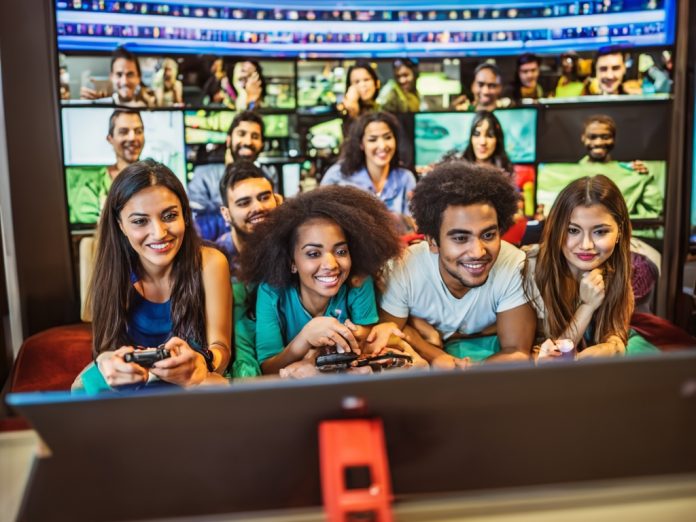 People watching videos with subtitles in various languages on a large screen.