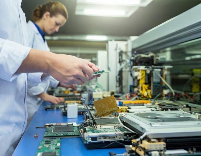Close-up view of intricate electronic circuit board assembly in manufacturing environment