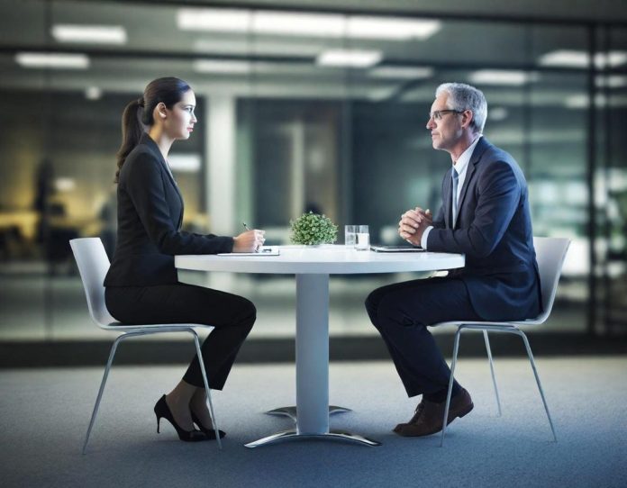Two technology executives engaged in serious conversation in a modern office setting