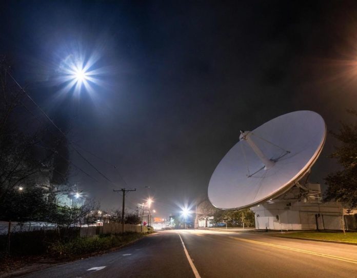 Satellite dish installation in urban environment during nighttime, representing alternative internet access methods