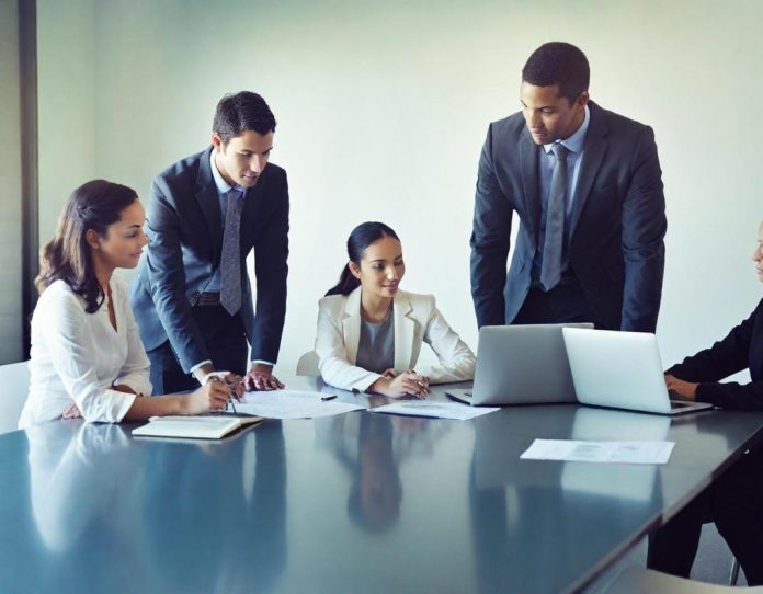 Young professionals collaborating in modern office environment discussing work documents