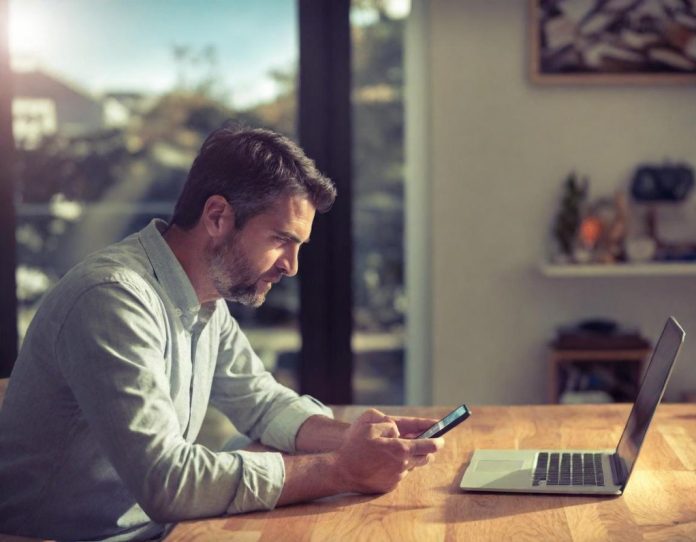 Person reviewing digital task assignments on smartphone in home office setting