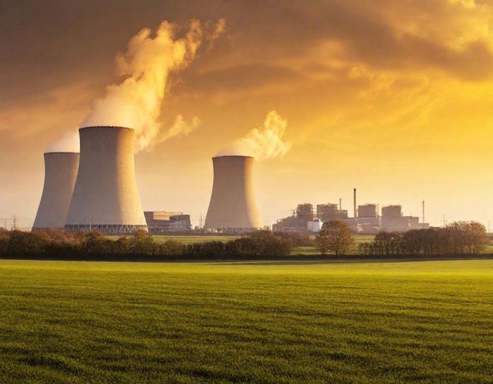 Large data center facility with cooling towers emitting steam at sunset, representing the physical infrastructure of artificial intelligence