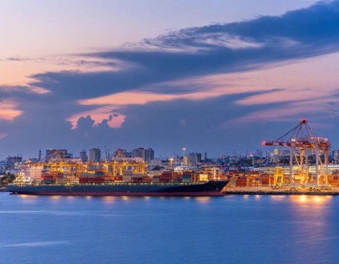 Global shipping containers being loaded at industrial port during dusk hours