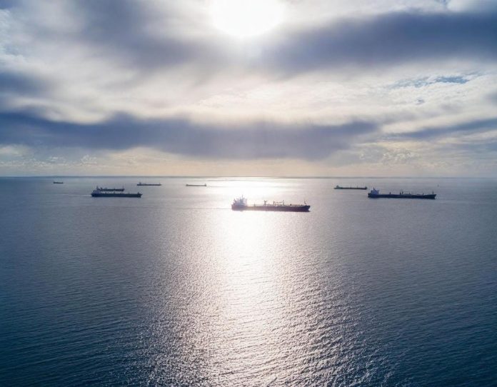 Oil tankers queued in ocean near strategic shipping lane during geopolitical disruption